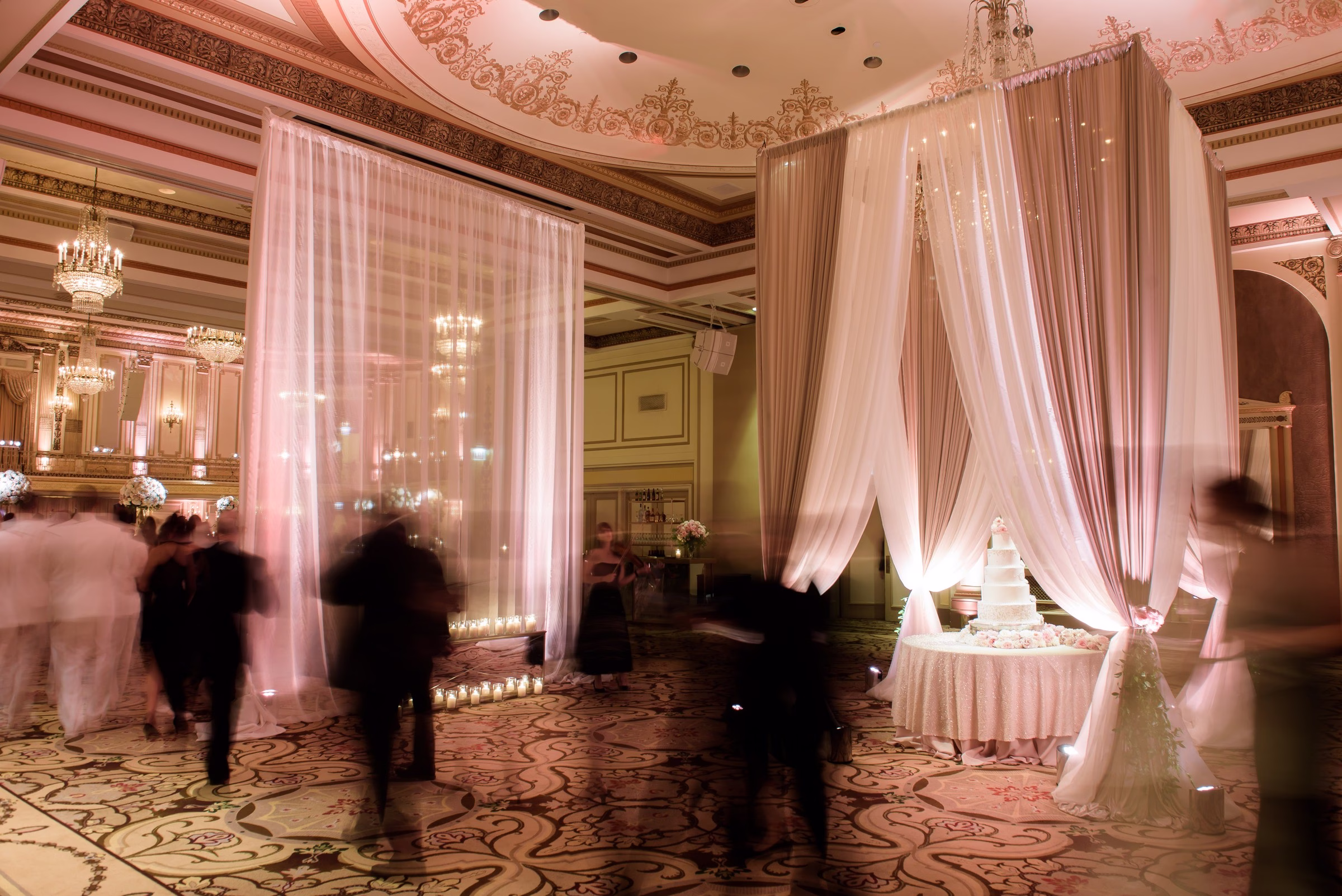Elegant ballroom wedding reception with flowing fabric draping and lighting design by Chicago wedding planner Erin McDonald
