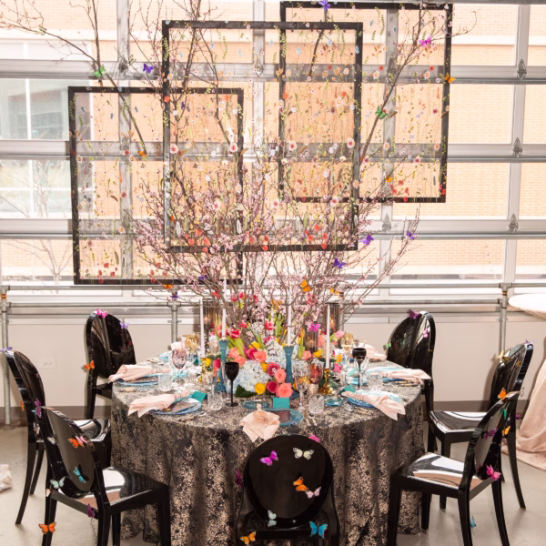 Elegant butterfly-themed wedding tablescape with black sequin linens and colorful floral centerpiece designed by Chicago wedding designer Erin McDonald