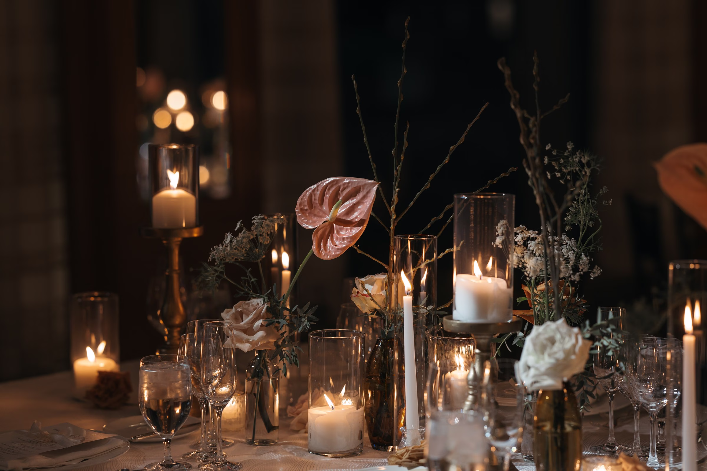 Elegant candlelit wedding reception tablescape with glass hurricane candles and floral arrangements designed by Chicago wedding designer Erin McDonald