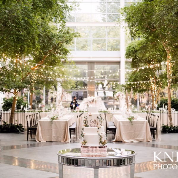 Elegant Chicago wedding reception design by Erin McDonald featuring string lights draped over trees with champagne linens and modern mirrored cake table