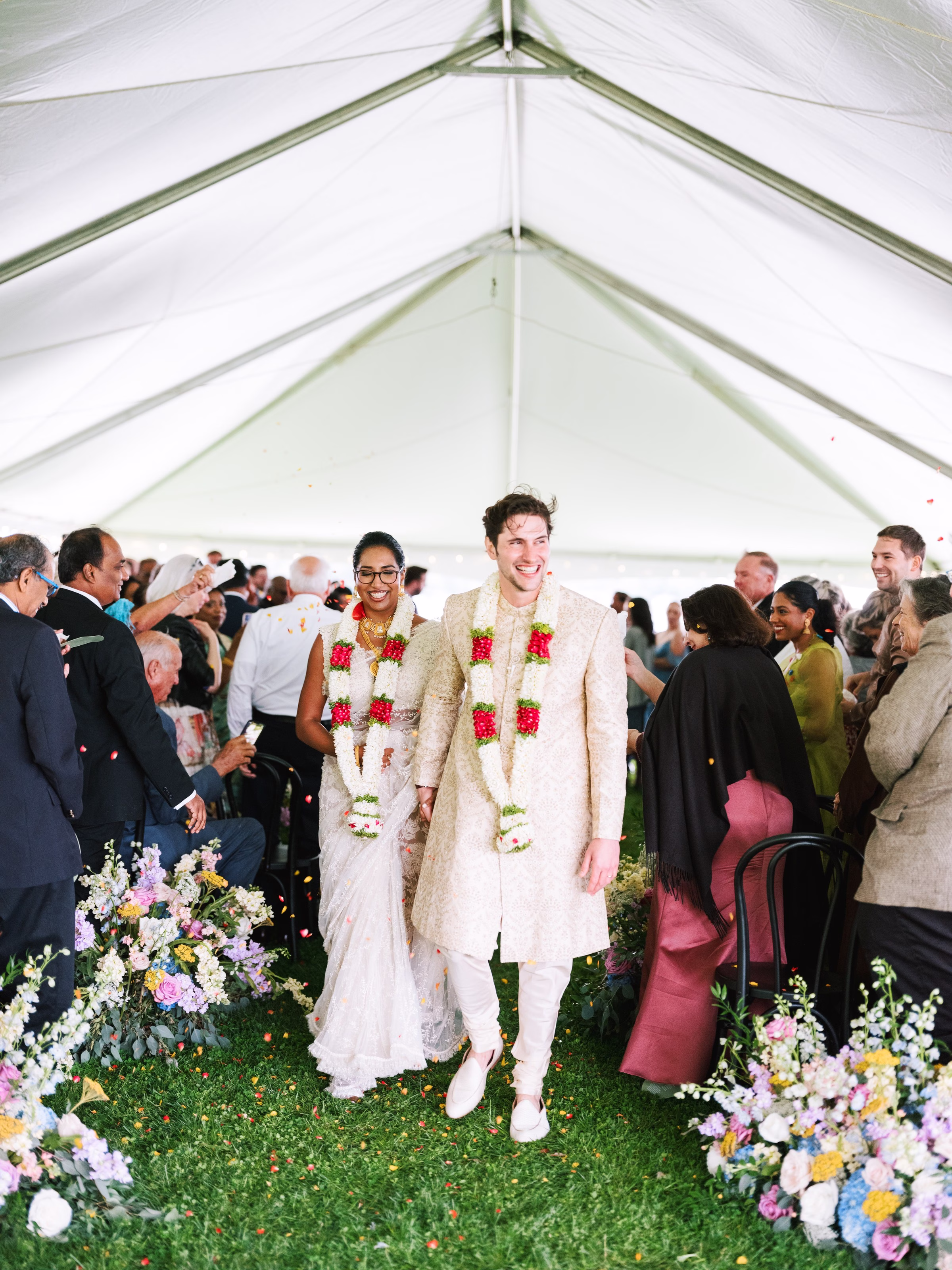 destination wedding designer erin mcdonald tent ceremony - Destination Event Design Newlyweds walking down aisle after Indian fusion wedding ceremony under white tent with floral arrangements designed by destination wedding designer Erin McDonald