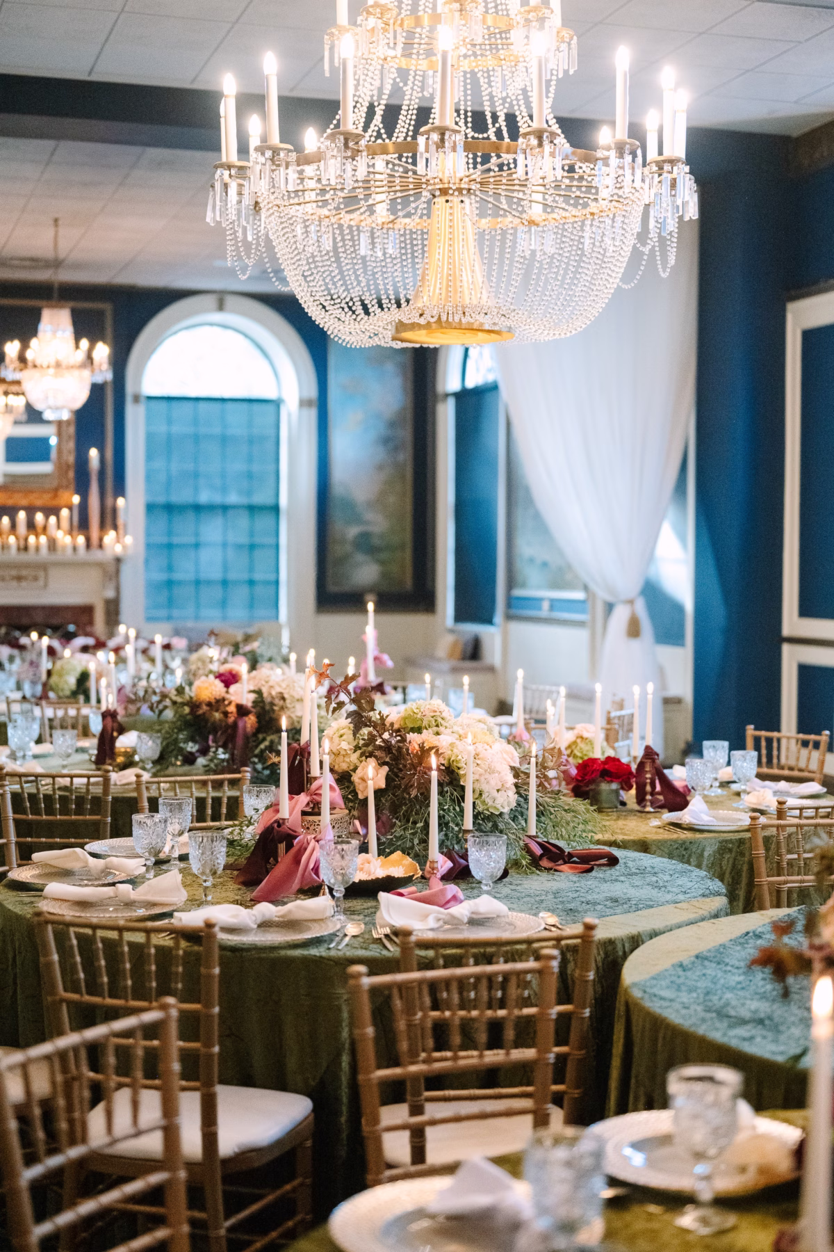 Elegant wedding reception tablescape with crystal chandelier and floral centerpieces at Inn on Broadway Rochester NY