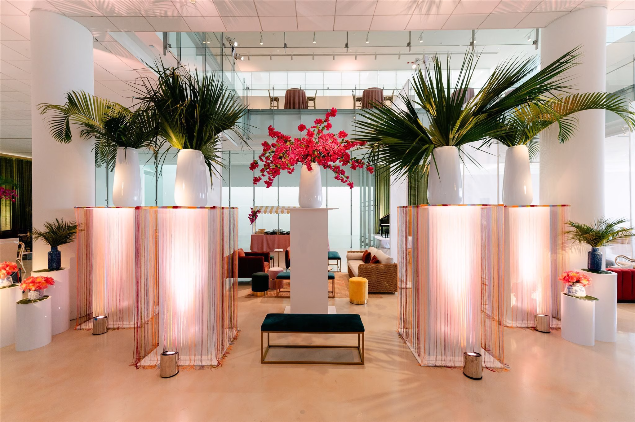 Elegant pink fringe ceremony arch with tropical palm arrangements and red bougainvillea designed by Erin McDonald