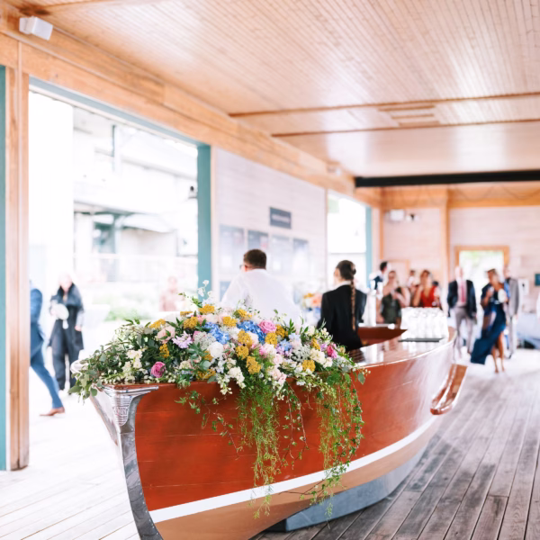 Colorful wildflower arrangement on vintage wooden boat at Rochester NY wedding designed by Erin McDonald