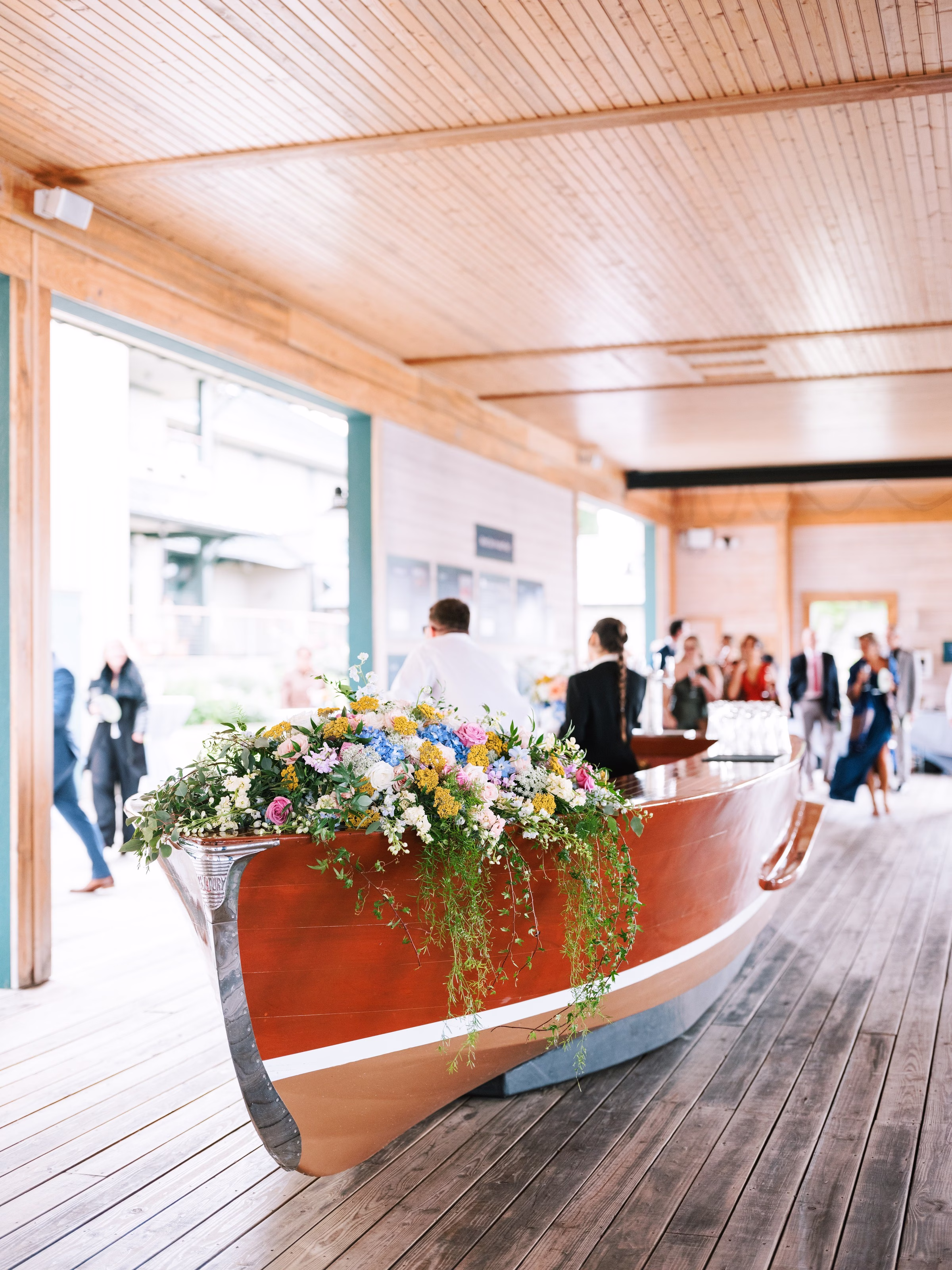 Colorful wildflower arrangement on vintage wooden boat at Rochester NY wedding designed by Erin McDonald