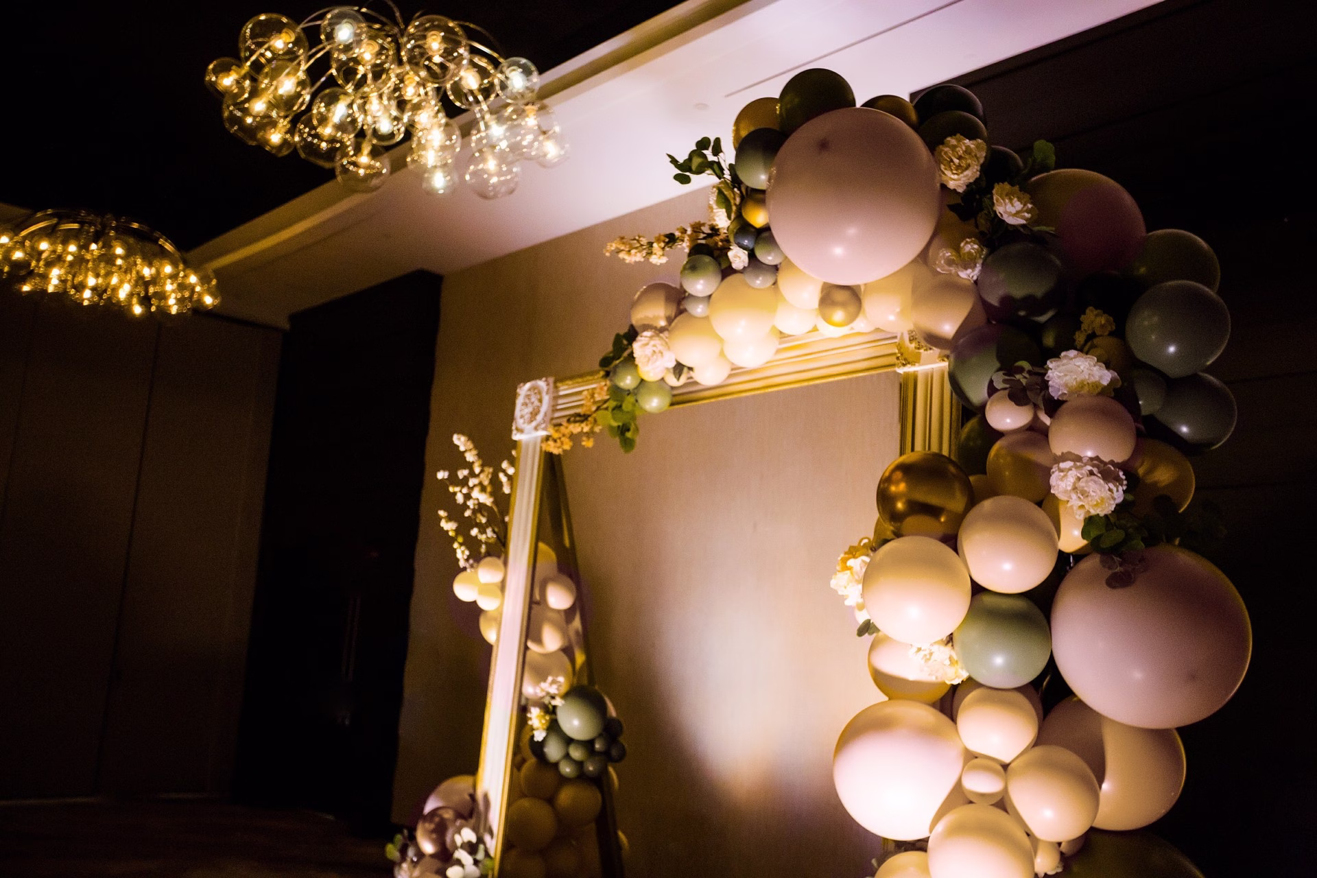 Elegant balloon arch backdrop with neutral tones and floral accents