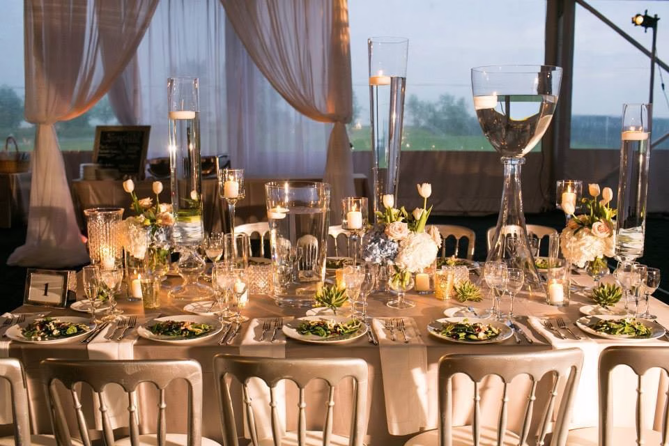 Elegant metallic wedding tablescape with floating candles and gold accents designed by Erin McDonald